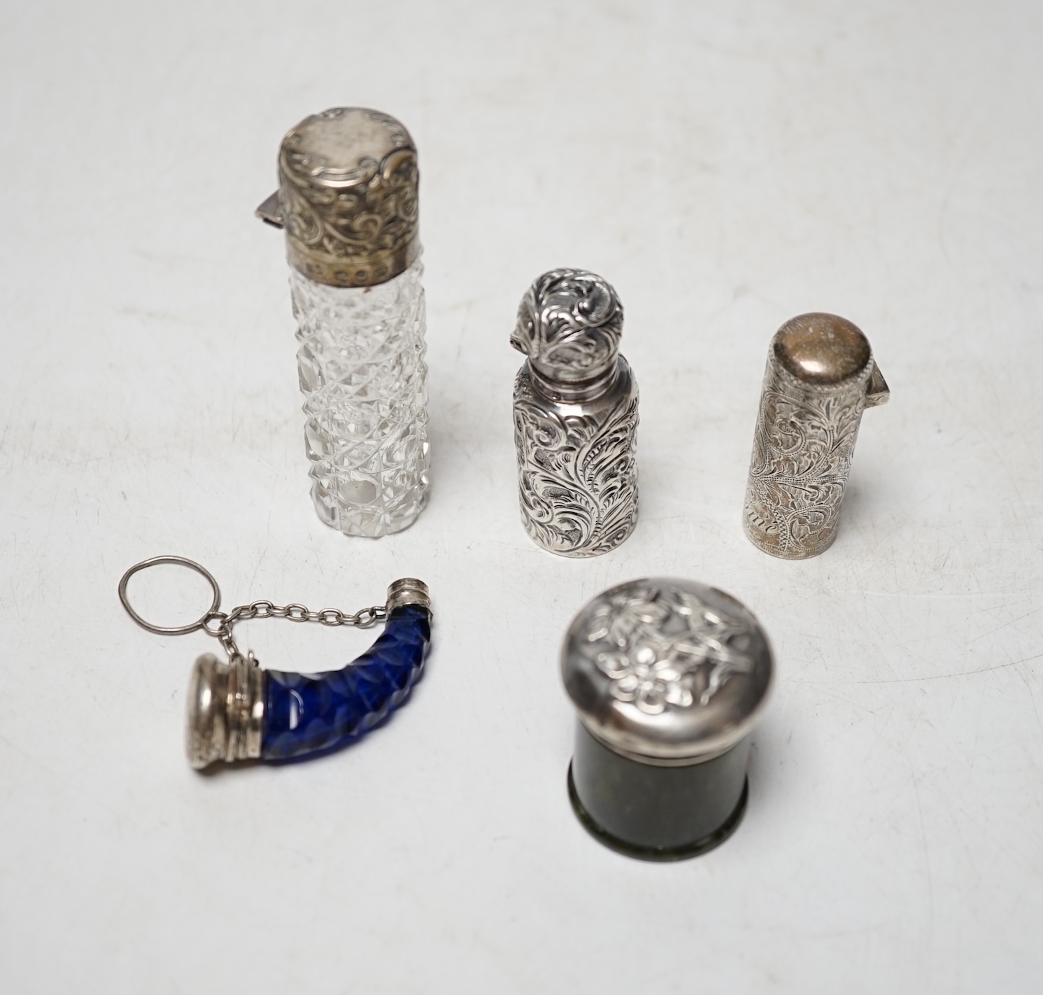 Four assorted late 19th/early 20th century silver or silver mounted scent bottles including engraved cylindrical by Hilliard & Thomasson, Birmingham, 1897, 47mm, together with a silver mounted hardstone toilet jar. Condi